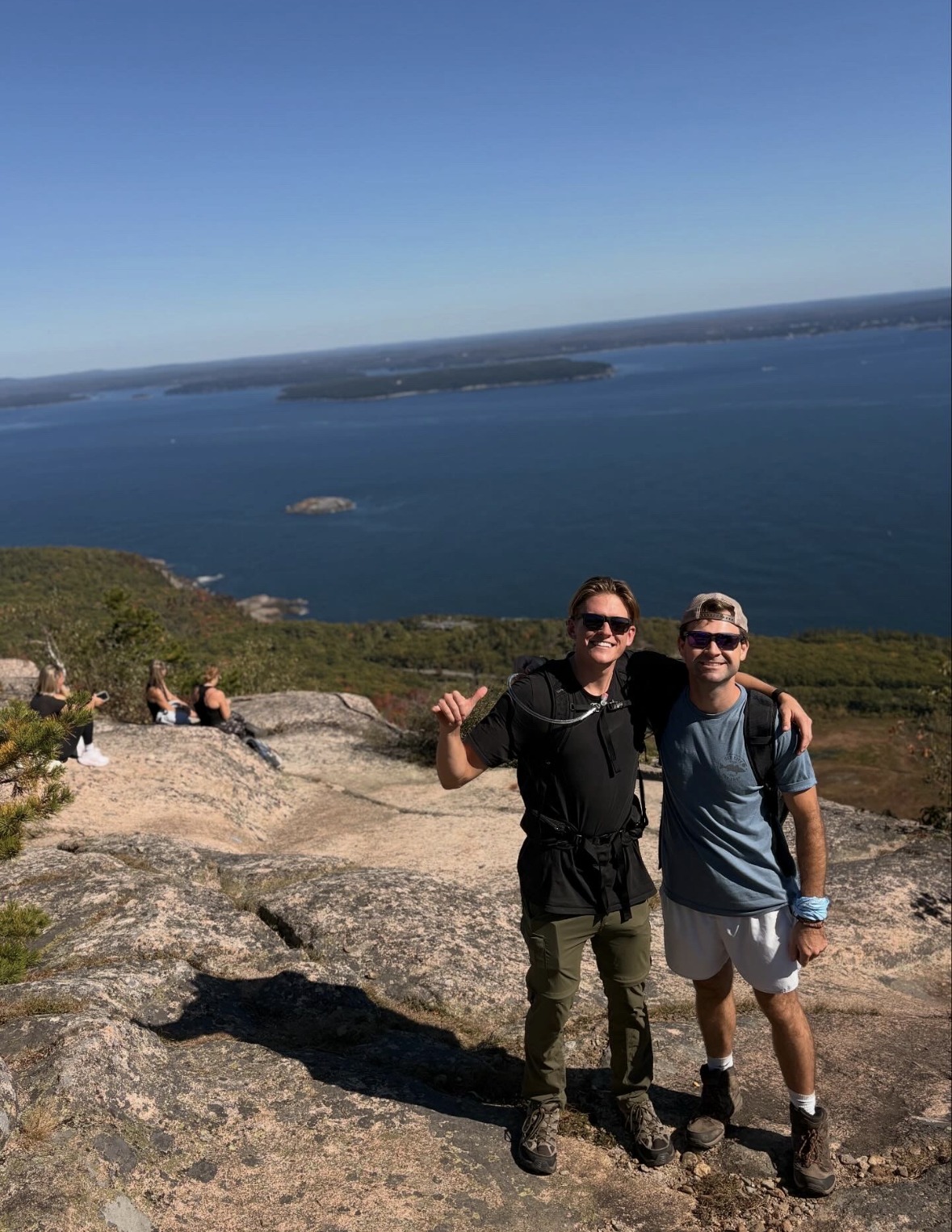 Two friends on a granite summit in Acadia National Park