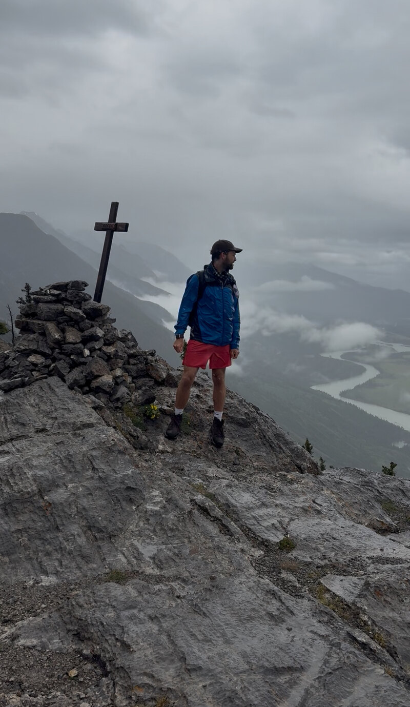 Standing beside a summit cross in low cloud