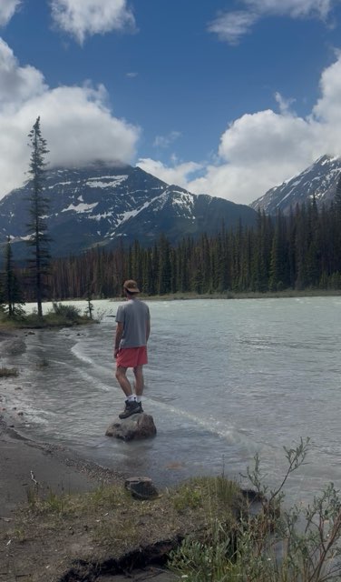 Standing at the edge of a glacial lake in Alberta